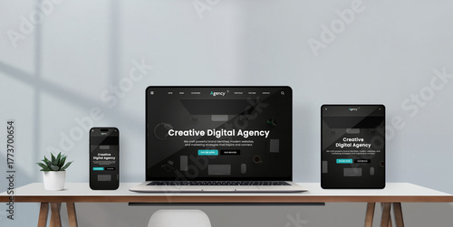 Laptop, tablet, and smartphone on minimalist desk display creative digital agency responsive website interface in dark mode, modern workspace with natural light