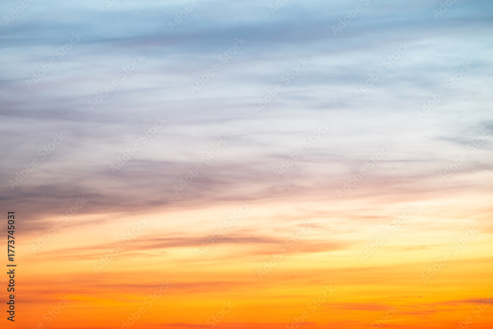 Obraz premium Sunset or sunrise sky with a vibrant gradient of orange, gold, and soft blue. Clear atmosphere with wispy clouds. Peaceful, natural light background. hope, freedom, new day and inspirational Concepts