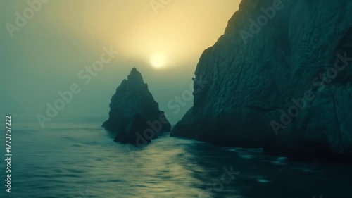 Hazy Golden Sunset Illuminating Dramatic Coastal Rocks and Jagged Sea Stacks at Dusk with Misty Ocean Water