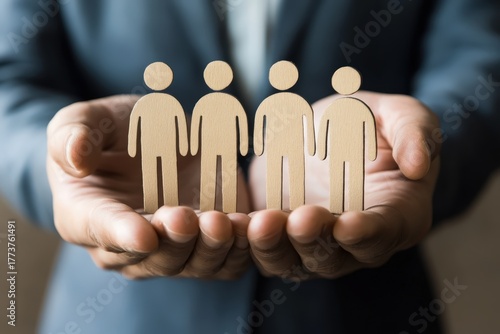 Caring Hands & Human Figures: A gentle close-up captures hands cradling the delicately crafted wooden figures of individuals, emphasizing the core value of human resource.
