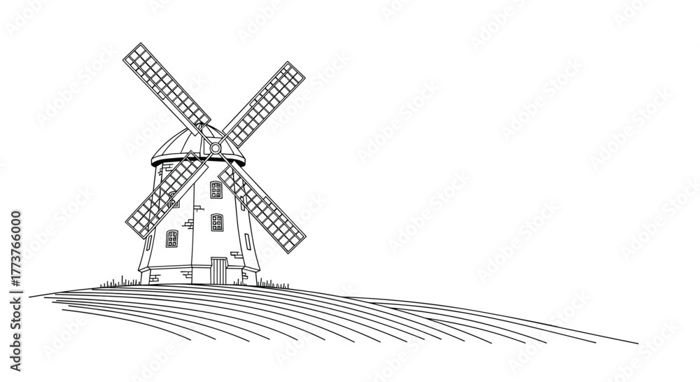 Fototapeta premium A picturesque vintage windmill stands majestically atop a gentle hill casting a long shadow on the grassy terrain beneath.