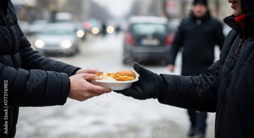 Hands exchanging food on snowy street - winter helping gesture