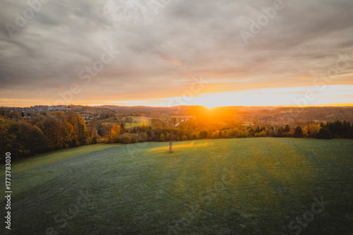 Aerial View of Autumn Forests and Misty Fields at Sunrise
