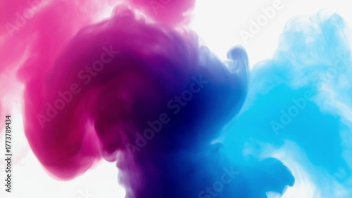 Vibrant pink and blue inks swirl and blend in water, creating abstract, cloud-like patterns against a white background