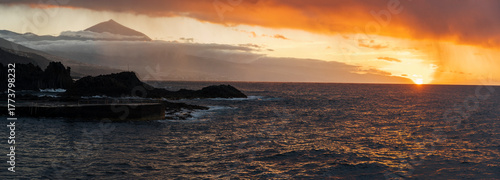 Sunset over the Atlantic Ocean with Mount Teide in the background, Tenerife, Canary Islands, Spain. Beautiful golden light illuminating the sky and sea, capturing the island’s volcanic landscape