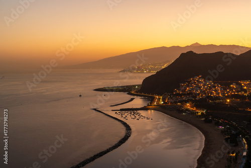 Sunset over the Atlantic Ocean with Mount Teide in the background, Tenerife, Canary Islands, Spain. Beautiful golden light illuminating the sky and sea, capturing the island’s volcanic landscape