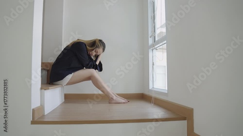 Upset young female holding her head, crying and feeling deeply worried and overwhelmed by sadness or a personal problem