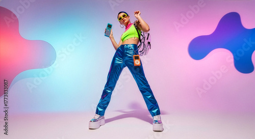 A full-length, wide-angle shot of a young woman posing confidently in exaggerated 90s/Y2K-inspired fluorescent and metallic fashion, holding a calculator and an orange portable player.