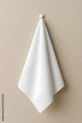 White towel hanging on beige wall