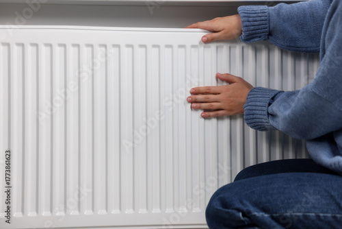 Wallpaper Mural Woman warming her hands near radiator indoors, closeup. Space for text Torontodigital.ca