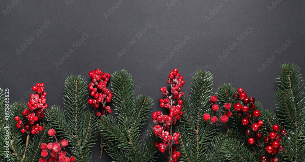 Obraz premium Flat lay composition with fir tree branches and Christmas decor on black background. Space for text