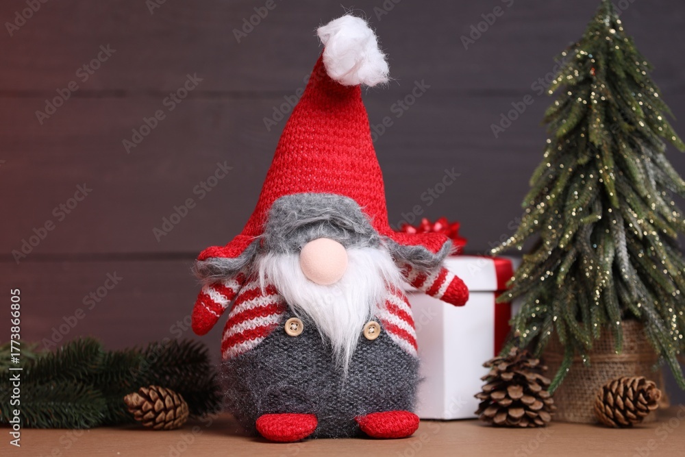 Naklejka premium Funny Christmas gnome and festive decor on wooden table