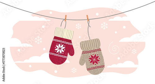 A charming illustration features two cozy, knitted mittens adorned with snowflake and floral designs, hanging on a clothesline against a soft pink backdrop with subtle cloud and snow details.