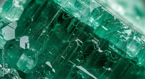 Close-up view of emerald green crystal formations with intricate geometric structures and reflective surfaces