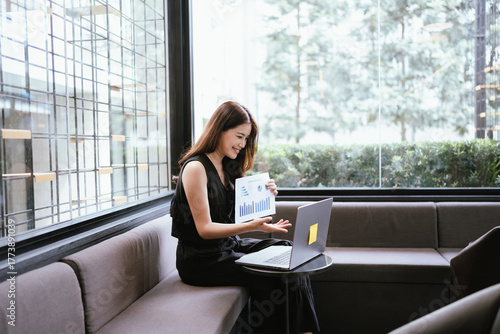 Free Download Young woman working on a laptop in a cozy cafe, focused on her tasks in a calm and modern workspace. - GFXLoad