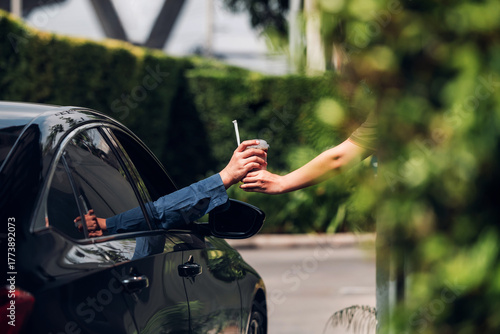 Fényképezés Hand Man in car receiving coffee in drive thru fast food restaurant