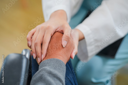 close-up shows a male doctor gently placing his hand on an elderly patient’s back, offering comfort, care, and reassurance during treatment. The compassionate gesture reflects empathy, professionalism