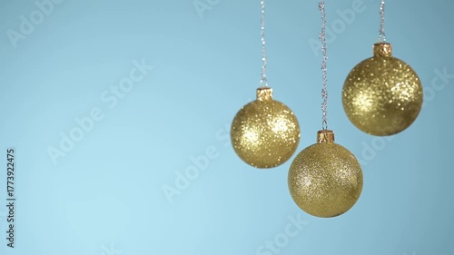Golden Christmas balls swinging on a blue background