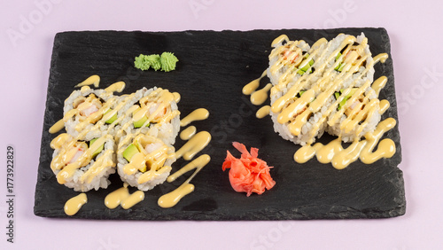 Gourmet salmon sushi rolls served on a black plate with garnishes, ready for a fine dining experience