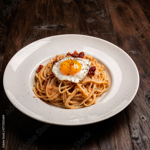Delicious creamy spaghetti carbonara topped with crispy bacon and a fried egg