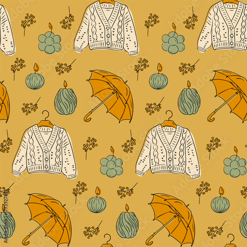 Cozy autumn seamless pattern with sweaters, umbrellas, candles and twigs in warm earthy tones. Concept of hygge lifestyle, comfort and seasonal relaxation