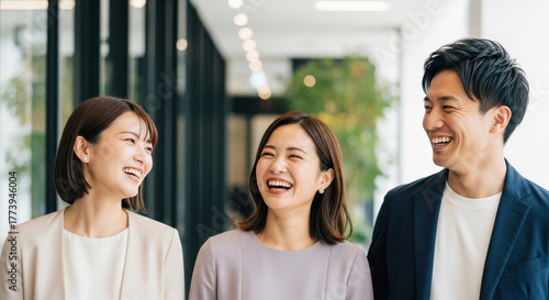 オフィスで笑い合う若手ビジネスパーソンのチーム