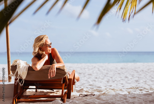 Stylish mature woman relaxing on tropical beach vacation