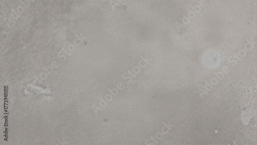 The image depicts a plain, textured surface with subtle color variations, resembling a neutral, grayish background.