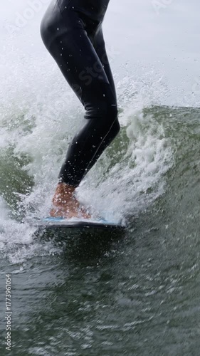 A Close-Up Perspective of a Surfer Skillfully Riding a Wave While Balancing on a Surfboard in Dynamic Ocean Conditions
