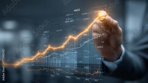 Hand drawing glowing orange line graph on a futuristic holographic display, symbolizing financial growth, business success, data analysis, and market investment.