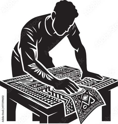 Silhouette of a Man Printing a Pattern on Fabric Using Tradition