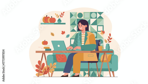 Smiling woman working remotely on her laptop in a cozy autumnal home office environment