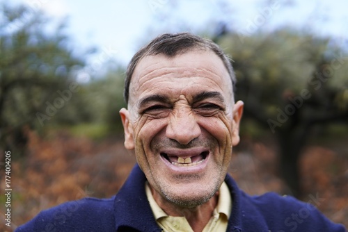 A cheerful middle-aged man smiles and poses. The man expresses joy and friendliness in a series of sincere and natural portraits.