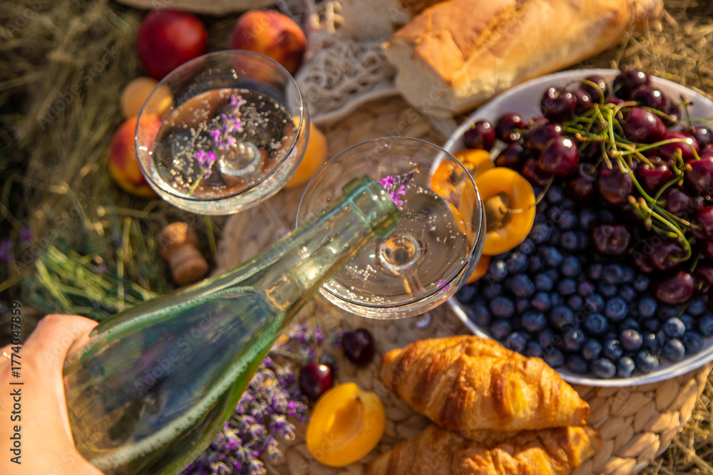 Naklejka premium Picnic with wine in a lavender field. Selective focus.