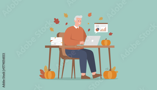 Mature professional works on laptop surrounded by autumn leaves and pumpkins