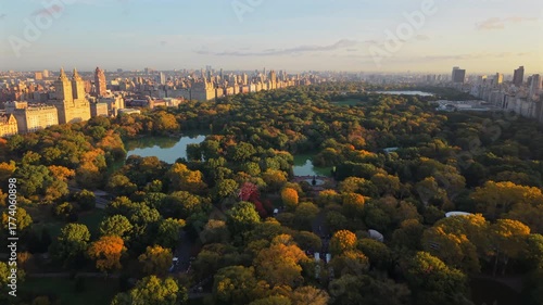 Beautiful Drone view of New York City Central Park during fall season, showcasing vibrant foliage, skyline, and morning sunlight atmosphere. Perfect travel destination in New York, USA