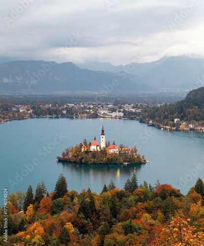 A small island with a forest and interesting houses is located in the middle of a wild lake. Beautiful landscapes of Slovenia, Lake Bled.