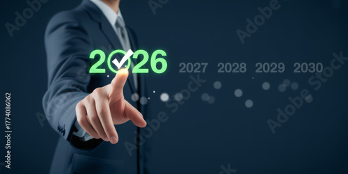 Businessman selecting 2026 with a checkmark planning for future years and forecasting business growth