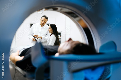 Medical professionals discussing patient care in a modern CT scanner room, showcasing advanced technology and a focus on healthcare innovation and patient comfort