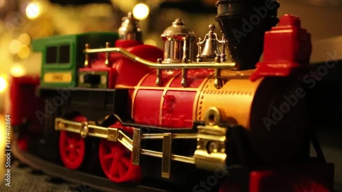 small Christmas season toy train with Christmas lights in the background 