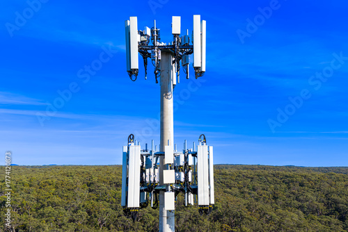 Drone aerial photograph of the top section of a large Cellular Tower against a bright blue sky background in the Blue Mountains, New South Wales, Australia.