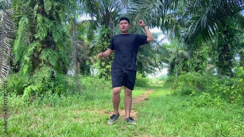 Active man performing leg workout in nature surrounded by green trees