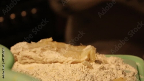 close-up of a woman's hands breading and preparing fish 