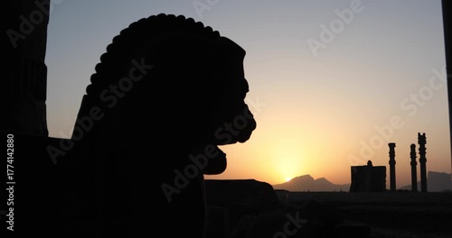 Silhouetted winged bull capital and ancient columns of Persepolis at sunset as the sun drops behind the Zagros. A quiet frame of heritage, empire and endurance across Iran’s desert horizon.