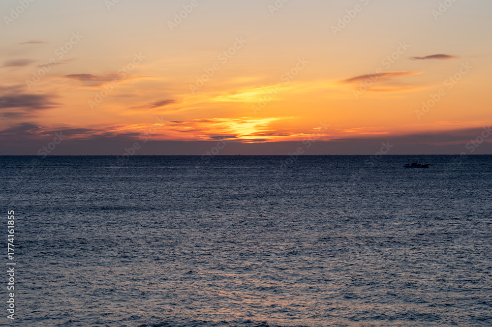 Naklejka premium 冬の海のオレンジ色の夜明け