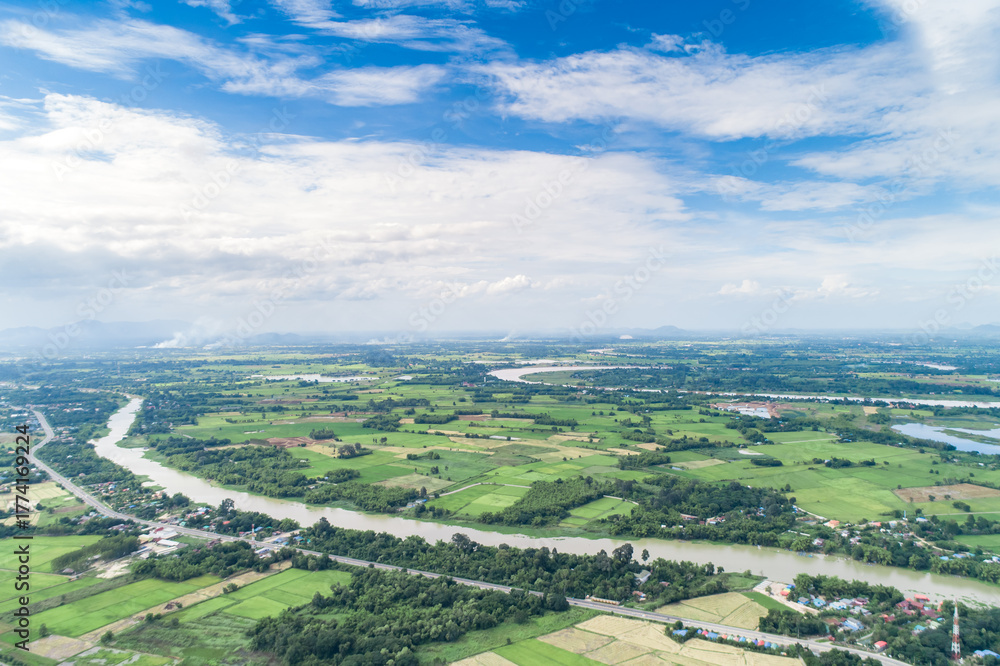 Naklejka premium Top view of the Sakae Krang River, Uthai Thani Province where both sides of river are filled with lush green trees. There are community near waterside.