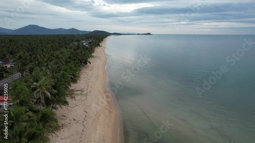 Aerial view of the sea, white beach and rural community in southern Thailand