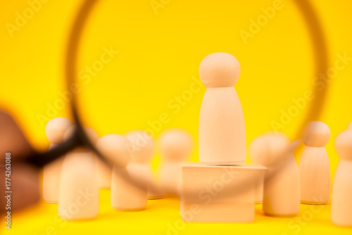 Quadro em tela Magnifying glass focusing on a standout figure among a team to represent recruitment, talent search, and candidate selection