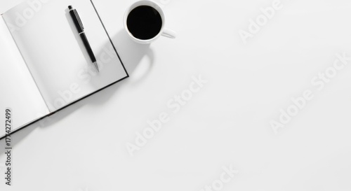 A minimalistic workspace with a laptop and a coffee cup on a white table, free space for text