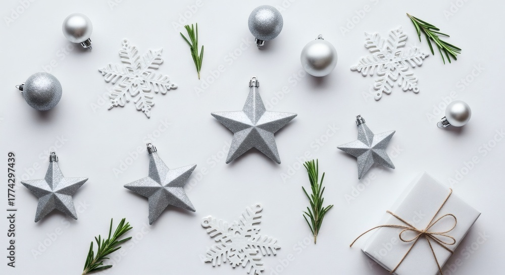 Obraz premium Elegant Silver Christmas Ornaments Stars Snowflakes and Gift Box Flat Lay on White Background